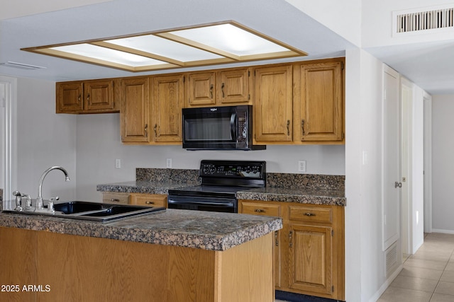 kitchen featuring dark countertops, visible vents, brown cabinets, black appliances, and a sink