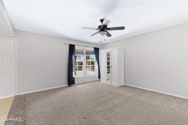 spare room featuring light carpet, ceiling fan, and baseboards