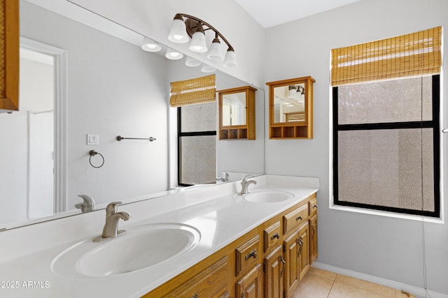 bathroom with a sink, baseboards, double vanity, and tile patterned floors