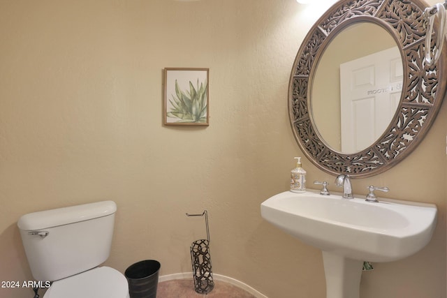 half bathroom featuring a sink and toilet