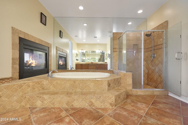 bathroom with a tiled fireplace, tile patterned floors, and separate shower and tub