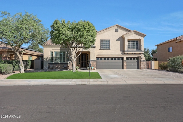 mediterranean / spanish house featuring a front yard, a garage, concrete driveway, stone siding, and stucco siding