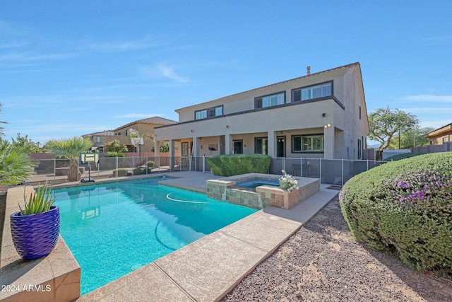 view of swimming pool with a patio, fence, and a pool with connected hot tub