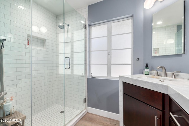 bathroom with vanity, hardwood / wood-style floors, and a shower with shower door