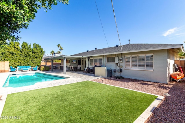 back of property featuring a patio, an outdoor living space, a yard, central air condition unit, and a fenced in pool