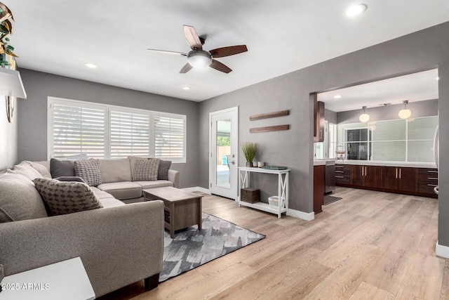 living room featuring ceiling fan and light hardwood / wood-style floors