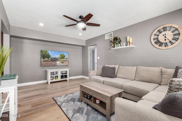 living room with wood-type flooring and ceiling fan