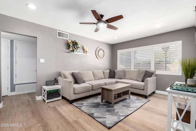 living room featuring ceiling fan and light hardwood / wood-style floors