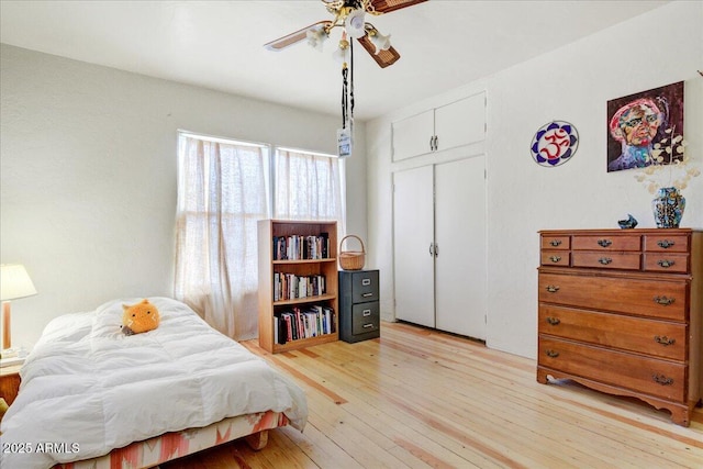 bedroom with a closet, light wood-type flooring, and a ceiling fan