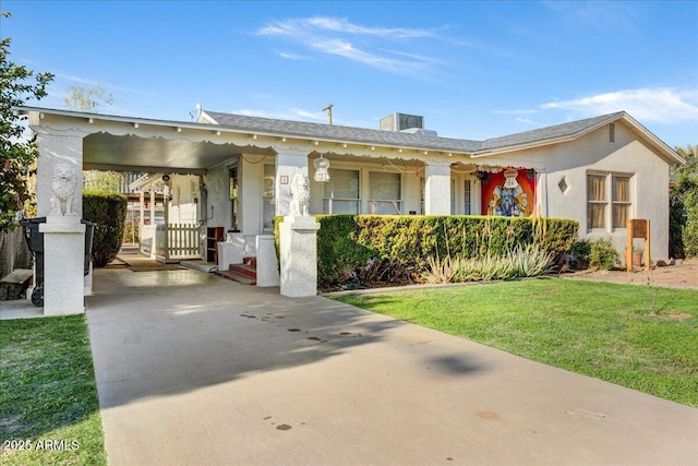 view of front of home featuring an attached carport, driveway, a front yard, and stucco siding
