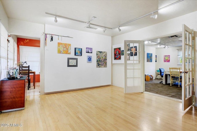 interior space featuring visible vents, french doors, track lighting, and wood finished floors