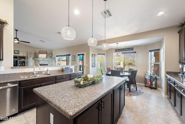 kitchen with stainless steel dishwasher, dark brown cabinets, visible vents, and a sink