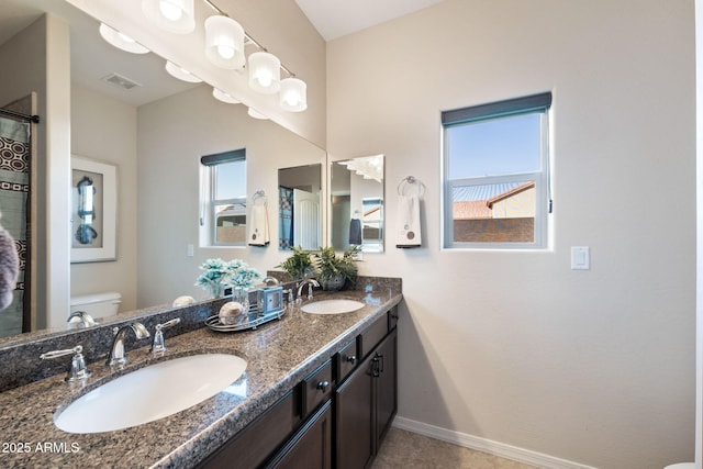 full bath with visible vents, toilet, baseboards, and a sink