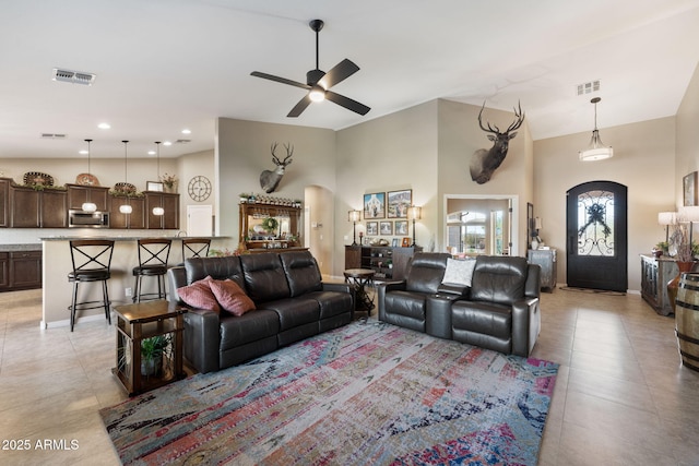 living area featuring visible vents, ceiling fan, recessed lighting, arched walkways, and high vaulted ceiling