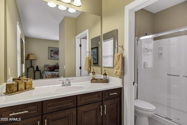 bathroom featuring vanity, toilet, and a shower with shower door