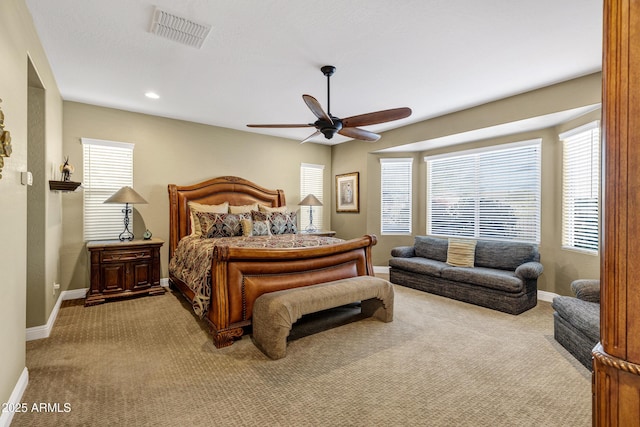 bedroom featuring light carpet, multiple windows, and ceiling fan