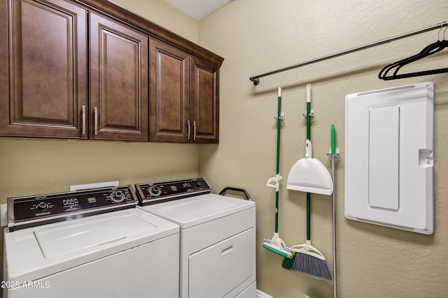 clothes washing area featuring separate washer and dryer and cabinets