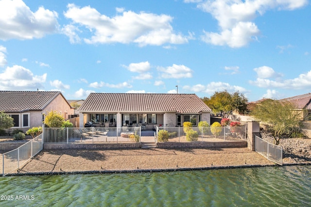 rear view of house featuring a patio area and a water view