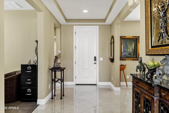 foyer with a raised ceiling