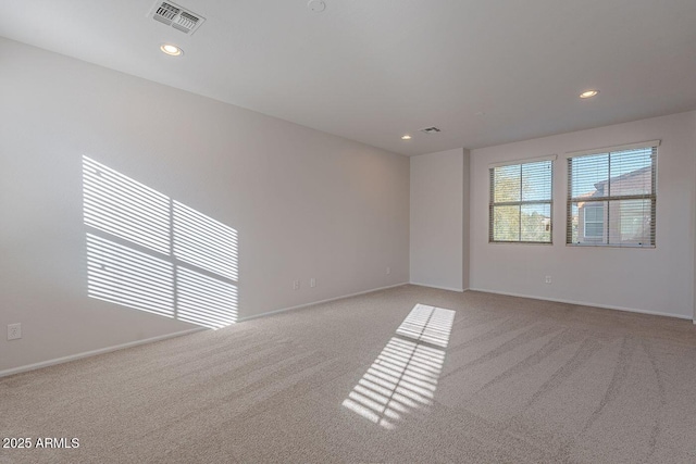 empty room featuring light carpet, visible vents, recessed lighting, and baseboards