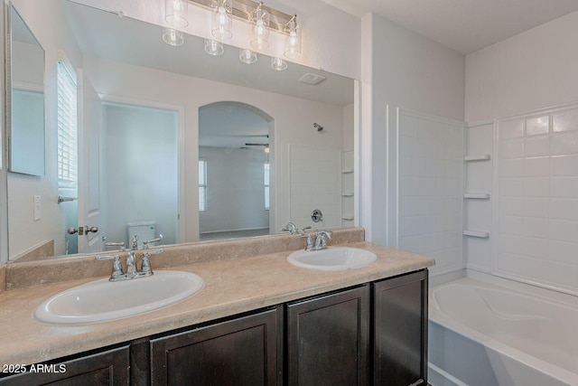 full bath featuring double vanity, toilet, tub / shower combination, and a sink