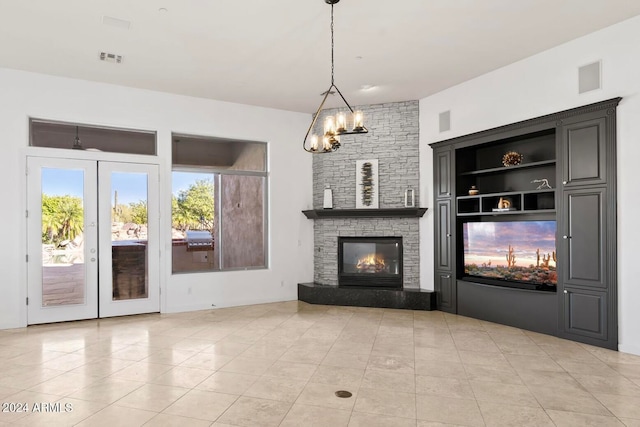 unfurnished living room featuring built in features, a fireplace, light tile patterned floors, and french doors