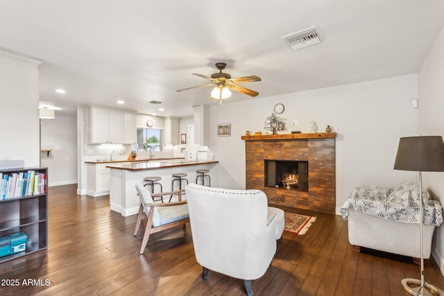 1649 W Royal Palm Rd, Phoenix, AZ 85021 - living room with a ceiling fan, a fireplace, dark wood-style flooring, recessed lighting, and baseboards