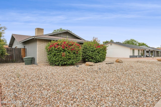 1649 W Royal Palm Rd, Phoenix, AZ 85021 - view of home's exterior featuring a chimney, brick siding, and fence