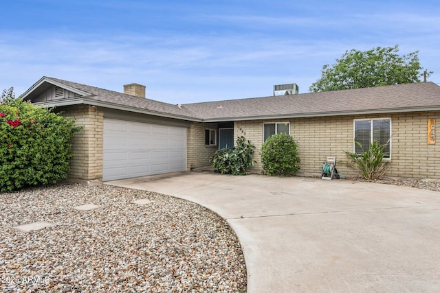 1649 W Royal Palm Rd, Phoenix, AZ 85021 - ranch-style home with concrete driveway, brick siding, an attached garage, a chimney, and roof with shingles