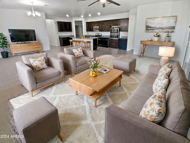 living room featuring ceiling fan with notable chandelier