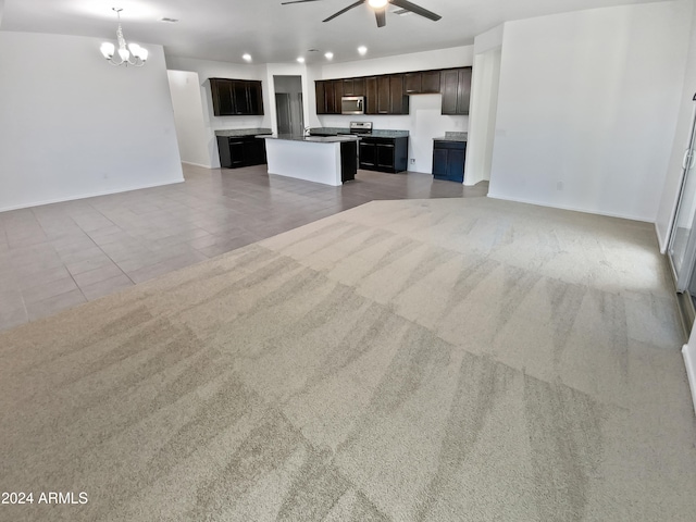 unfurnished living room featuring ceiling fan with notable chandelier and carpet floors