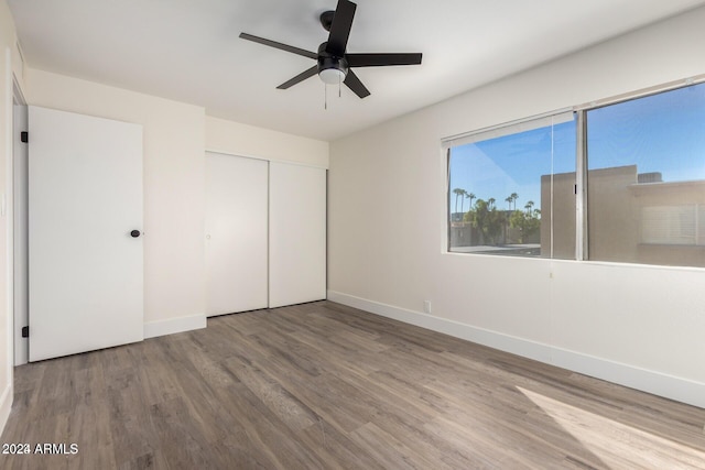 unfurnished bedroom with a closet, hardwood / wood-style flooring, and ceiling fan