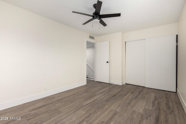 unfurnished bedroom featuring ceiling fan, dark wood-type flooring, and a closet