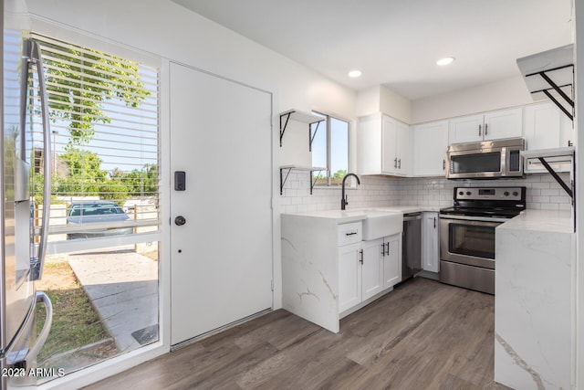 kitchen featuring plenty of natural light, dark hardwood / wood-style floors, white cabinetry, and appliances with stainless steel finishes