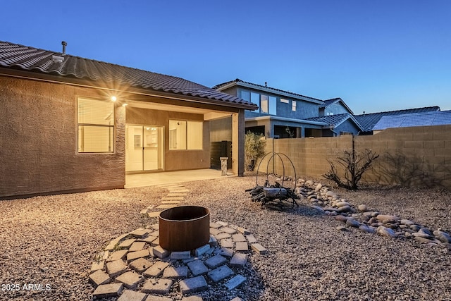 back of property with a patio, a tiled roof, fence, and stucco siding