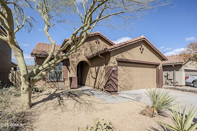 mediterranean / spanish home featuring a tile roof, a garage, driveway, and stucco siding