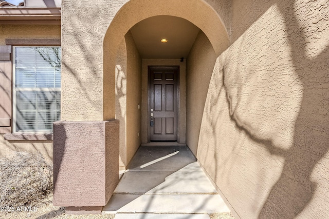 view of exterior entry with stucco siding