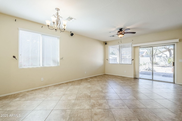 empty room with light tile patterned flooring, ceiling fan with notable chandelier, visible vents, and baseboards