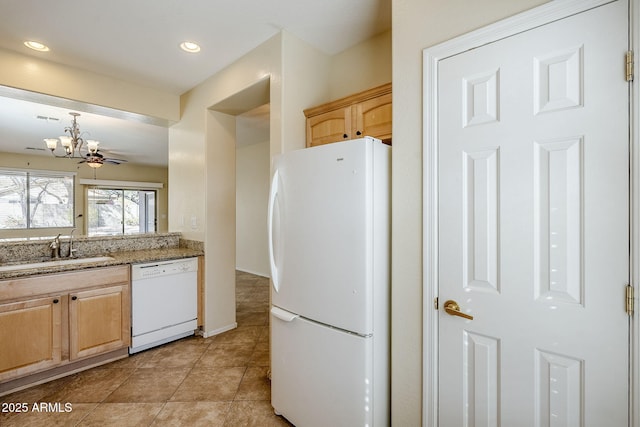 kitchen with a sink, white appliances, recessed lighting, and light brown cabinetry