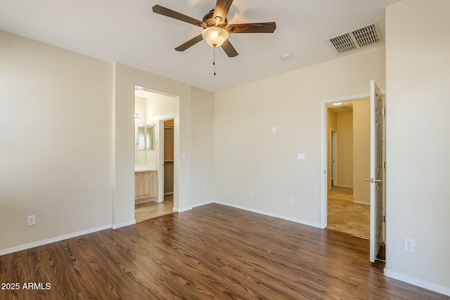 spare room with visible vents, baseboards, and wood finished floors