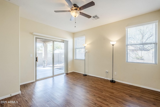 unfurnished room featuring a wealth of natural light, visible vents, and wood finished floors