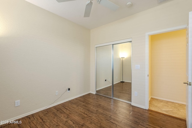 unfurnished bedroom featuring a closet, baseboards, and wood finished floors