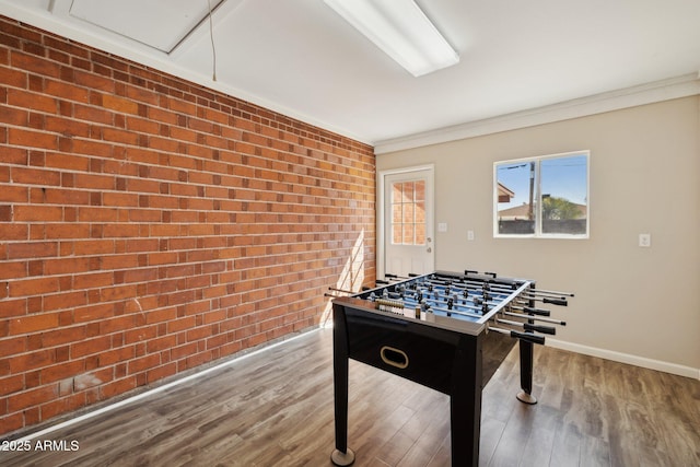 8107 E Mitchell Dr, Scottsdale, AZ 85251 - recreation room featuring crown molding, wood finished floors, baseboards, and brick wall