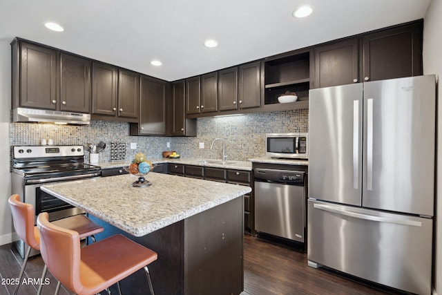8107 E Mitchell Dr, Scottsdale, AZ 85251 - kitchen with a sink, stainless steel appliances, dark brown cabinets, under cabinet range hood, and backsplash