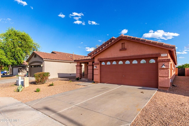 view of front of house with a garage, stucco siding, driveway, and a tiled roof