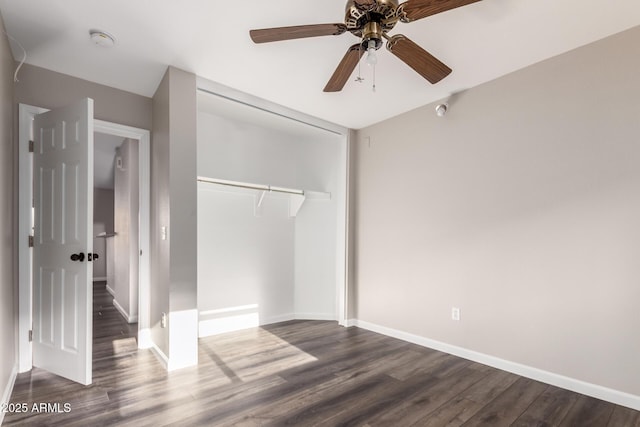 unfurnished bedroom with baseboards, a closet, and dark wood-type flooring