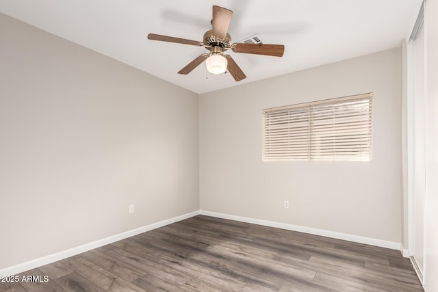 empty room featuring a ceiling fan, baseboards, visible vents, and wood finished floors