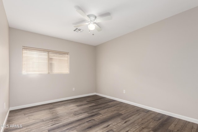 unfurnished room with a ceiling fan, baseboards, visible vents, and dark wood-type flooring