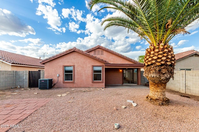 rear view of house featuring central AC, a fenced backyard, stucco siding, a patio area, and a tile roof
