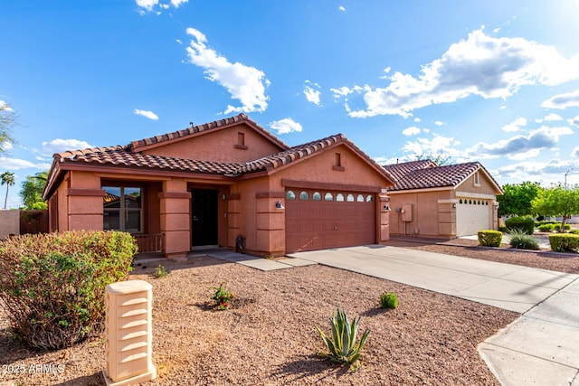 view of front of house featuring stucco siding, concrete driveway, a tile roof, and a garage